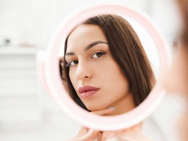 woman looking into mirror prideful